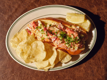 toronto-restaurants-st-johns-tavern-entertainment-district-lobster-roll A buttered brioche bun stuffed with lobster dressed with kewpie mayo comes with a side of kettle chips and a lemon wedge